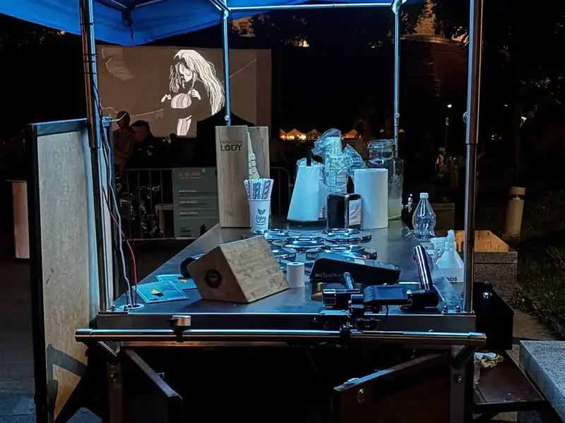 Mobilna budka z lodami podświetlona LED-ami wieczorem na festiwalu filmowym w Krakowie